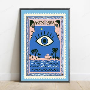 May include: A rectangular wall art print framed in black, designed to resemble a postage stamp with a serrated edge. The illustration features a large central eye, a crescent moon, two faces in profile, palm trees, and a building by the sea.