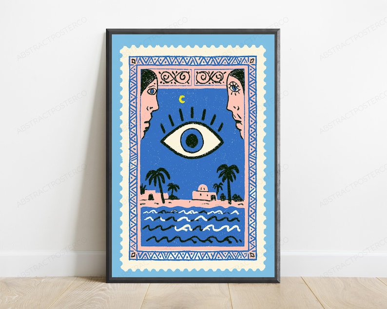 May include: A rectangular wall art print framed in black, designed to resemble a postage stamp with a serrated edge. The illustration features a large central eye, a crescent moon, two faces in profile, palm trees, and a building by the sea.