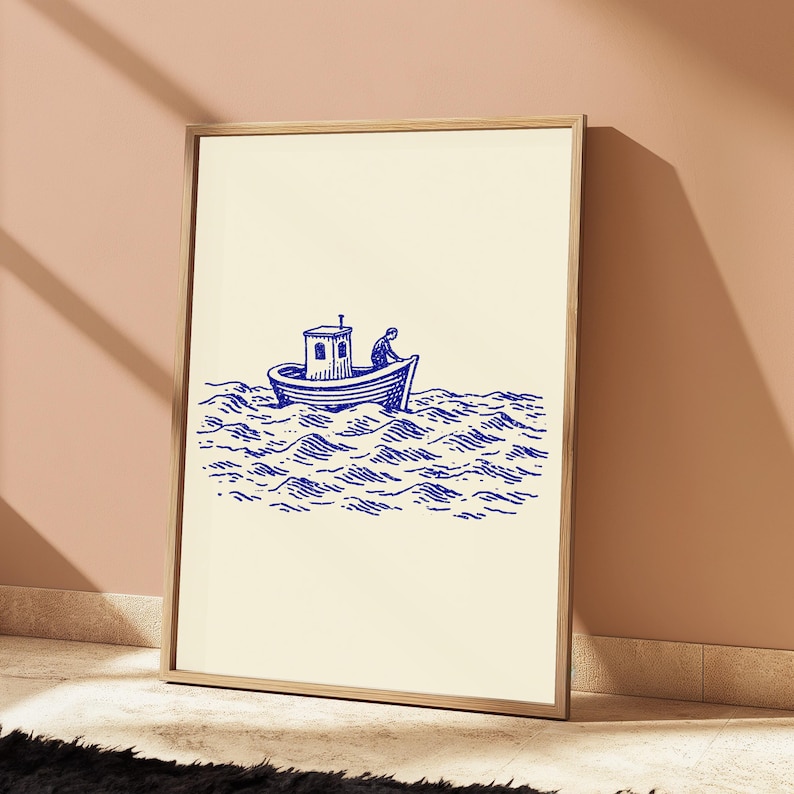 May include: A framed wall art print featuring a blue ink illustration on a cream background. The artwork depicts a small boat with a cabin floating on stylised, wavy water, with a single figure visible on the deck of the vessel.