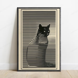 May include: A framed vertical wall art print featuring a black cat silhouette integrated into a pattern of horizontal black lines against a cream background. The cat is depicted in profile, facing right, with visible eyes and ears within the striped design.