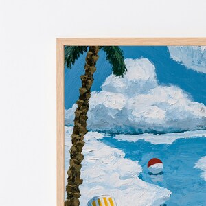 May include: An oil painting in a light wood frame depicting a beach scene with a tall palm tree in the foreground, white sand, a bright blue ocean, and a red and white beach ball floating in the water under a sky filled with large white clouds.