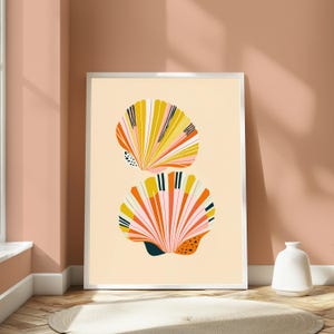 May include: A framed wall art print featuring two stylised seashells stacked vertically against a light cream background. The shells are illustrated with vibrant stripes of mustard yellow, coral pink, white, and dark navy blue, including small black dots.