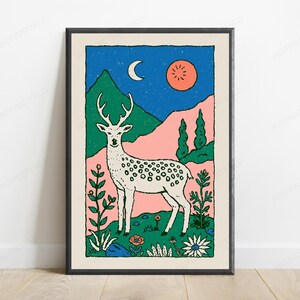 May include: A framed art print featuring a white spotted deer standing in a field of flowers. The background displays green mountains, a blue starry sky with a crescent moon, and a round orange sun. The illustration uses bold lines and colors.