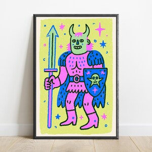 May include: A framed art print featuring a stylized illustration of a horned figure in pink armor, holding a blue sword and a blue shield with a skull emblem. The character has a light green face and is set against a bright lime green background.