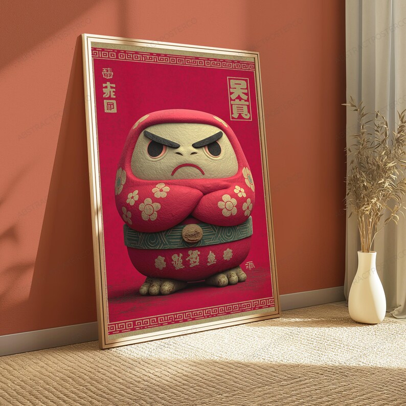 Peut inclure: Une affiche verticale encadr&eacute;e repr&eacute;sentant une poup&eacute;e Daruma rouge avec un visage cr&egrave;me, des sourcils noirs &eacute;pais et une expression s&eacute;v&egrave;re. La poup&eacute;e pr&eacute;sente des motifs floraux blancs sur les bras, une ceinture verte et des caract&egrave;res asiatiques.