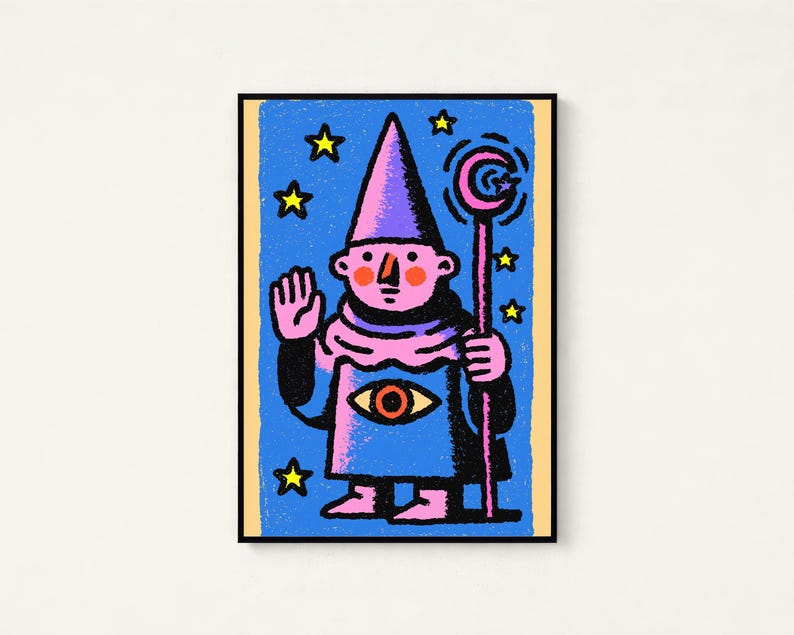 May include: A framed rectangular art print featuring a stylized illustration of a pink-skinned figure wearing a pointed hat and robe. The figure holds a staff with a crescent moon and has a large eye graphic on the chest, set against a blue background with yellow stars.