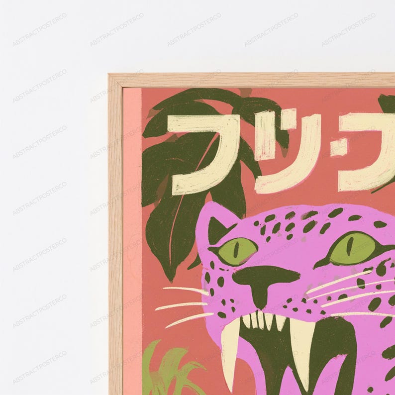 May include: A framed wall art print featuring a pink leopard with green eyes and dark spots against a coral background. The design includes dark green tropical leaves and large, cream-colored Japanese characters across the top portion of the print.