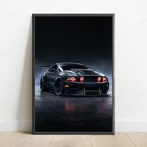 May include: A framed poster featuring a matte black sports car with a wide body kit, a rear spoiler, and glowing red circular headlights. The vehicle is positioned on a dark, reflective surface against a dark, moody, and atmospheric background.