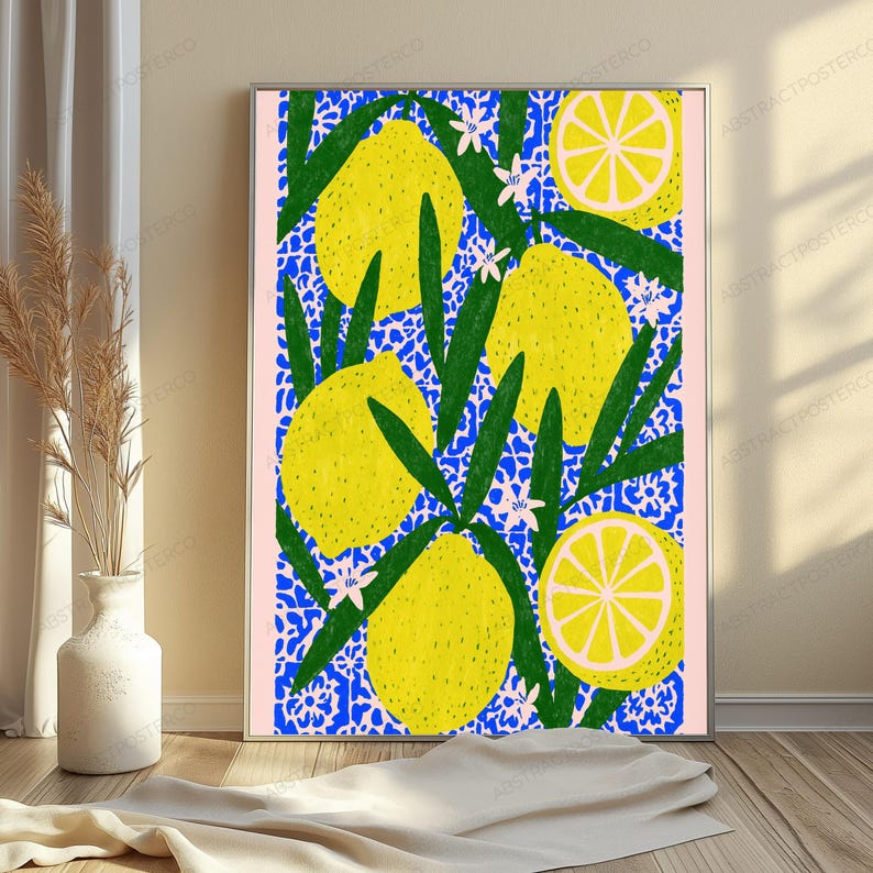 K&ouml;nnte beinhalten: Ein rechteckiger Wandkunstdruck mit einem lebendigen Muster aus leuchtend gelben Zitronen, gr&uuml;nen Bl&auml;ttern und kleinen wei&szlig;en Bl&uuml;ten vor einem komplexen blau-wei&szlig;en Blumenhintergrund, eingerahmt von einem d&uuml;nnen hellrosa Rand.