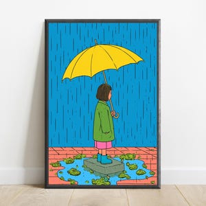 K&ouml;nnte beinhalten: Ein gerahmter Kunstdruck mit einer Cartoon-Illustration einer Person mit braunen Haaren, die w&auml;hrend eines Regenschauers auf einem Stein in einer Pf&uuml;tze steht. Die Person tr&auml;gt einen gr&uuml;nen Mantel, einen rosa Rock und blaue Stiefel unter einem gelben Regenschirm.