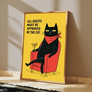 May include: A framed rectangular wall art print featuring a yellow background with a black cat wearing a red bandana, sitting in a red armchair, holding a martini glass, and the text: ALL GUESTS MUST BE APPROVED BY THE CAT.