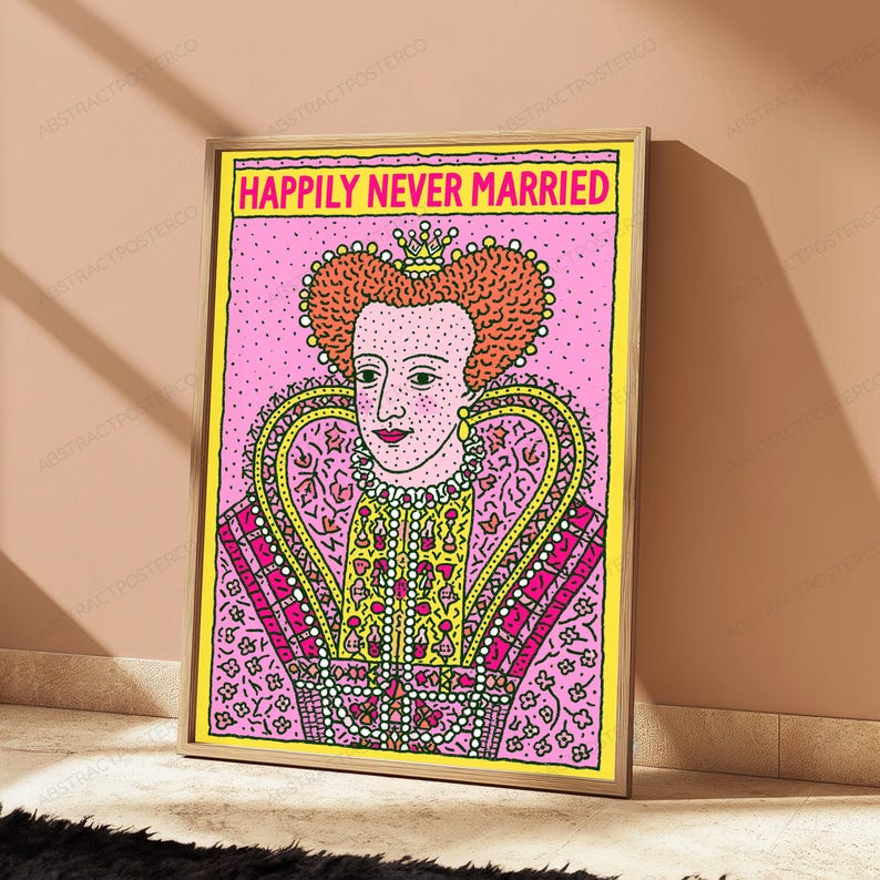 May include: A rectangular wall art print in a light wooden frame featuring a stylized illustration of a queen with orange hair, wearing a pink and yellow patterned gown. The text "HAPPILY NEVER MARRIED" is printed in bold pink letters at the top.