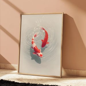 May include: A framed vertical wall art print featuring two koi fish swimming in light blue water. One fish is solid orange-red, while the other is white with orange-red patches. The water surface shows circular ripples and small bubbles.