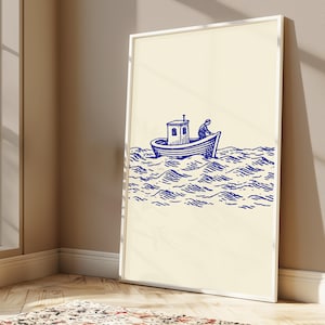 May include: A framed wall art print featuring a blue ink illustration on a cream background. The artwork depicts a small boat with a cabin and a single figure on board, navigating through stylised, wavy ocean water in a nautical line art style.