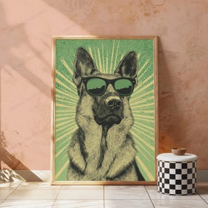 May include: A framed wall art print featuring a detailed illustration of a German Shepherd dog wearing dark sunglasses. The dog is centered against a light green background with radiating sunburst lines and a subtle dotted texture pattern.