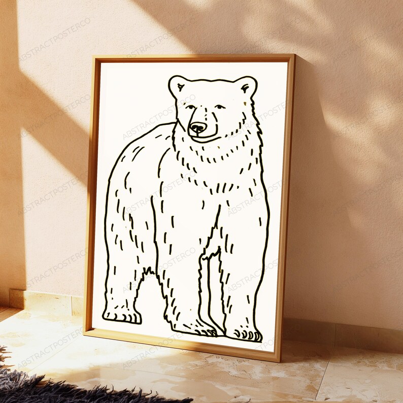 K&ouml;nnte beinhalten: Ein gerahmter Wandkunstdruck mit einer schwarzen Strichzeichnung eines stehenden B&auml;ren auf wei&szlig;em Hintergrund. Der B&auml;r ist in einem einfachen Stil mit sichtbaren Fellstrukturlinien dargestellt und befindet sich in einem hellen Holzrahmen.