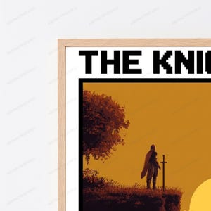 May include: A framed wall art print featuring a pixel art illustration of a knight standing on a cliffside with a sword at sunset. The text THE KNI is visible at the top in a black pixelated font. The frame is made of light-colored wood.