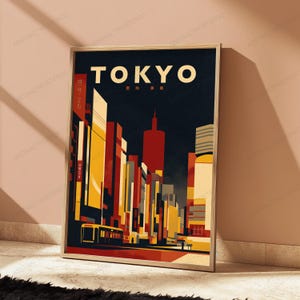 以下が含まれることがあります： 夜の東京の街並みをスタイリッシュなグラフィックで描いた額入りポスター。赤、オレンジ、黄色の色調で表現された高層ビルが暗い背景に浮かび上がり、上部にはTOKYOという文字が大きくプリントされています。