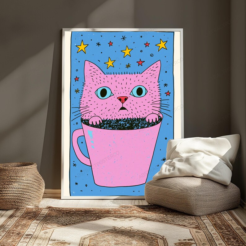 Pu&ograve; includere: Una stampa artistica da parete incorniciata raffigurante un gatto rosa con grandi occhi azzurri seduto all'interno di una tazza rosa. Lo sfondo &egrave; un campo azzurro riempito di stelle gialle e rosse e piccoli simboli neri a forma di stella.