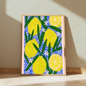 K&ouml;nnte beinhalten: Ein rechteckiger gerahmter Kunstdruck mit einem lebendigen Muster aus gelben Zitronen und gr&uuml;nen Bl&auml;ttern vor einem leuchtend blauen Blumenhintergrund. Die Komposition zeigt ganze Zitronen und Zitronenh&auml;lften, akzentuiert durch kleine wei&szlig;e Bl&uuml;ten.