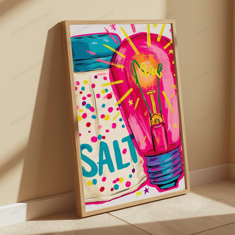 May include: A framed wall art print featuring a stylized illustration of a salt shaker with colorful confetti-like dots and the word SALT in large blue letters, next to a bright pink light bulb with yellow rays and the word glow in green script.