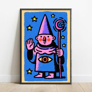 May include: A framed art print featuring a pink-skinned figure in a purple pointed hat and robe, holding a staff with a crescent moon topper. The figure has a large eye on the chest, a raised hand, and is set against a blue background with yellow stars.