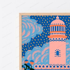 May include: A framed art print featuring a stylized pink lighthouse tower against a deep blue sky filled with light blue clouds and scattered yellow marks. The lighthouse has an orange roof and base, with a small arched window in the center.