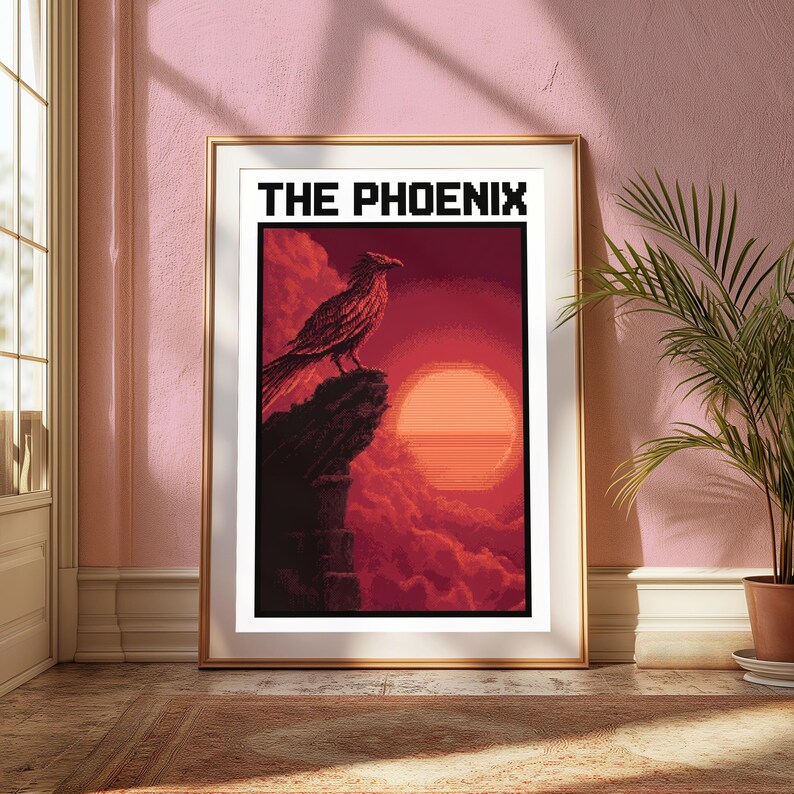 Puede incluir: Una l&aacute;mina de arte mural rectangular enmarcada con una ilustraci&oacute;n estilo pixel art de un p&aacute;jaro posado en el borde de un acantilado frente a un gran sol naranja y nubes rojas. El texto THE PHOENIX aparece en letras negras en la parte superior.
