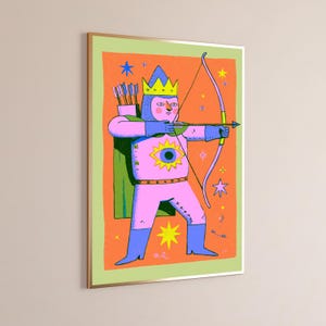 Puede incluir: Una l&aacute;mina de arte enmarcada que muestra una figura rosa con corona amarilla, botas azules y capa verde. La figura sostiene un arco y una flecha sobre un fondo naranja con estrellas amarillas. Un gran ojo amarillo est&aacute; centrado en el pecho.