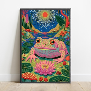 Op de afbeelding: Een ingelijste verticale kunstdruk met een grote roze en groen gevlekte kikker in een vijver, met een felroze waterlelie op de voorgrond. De achtergrond toont een donkerblauwe lucht met een gloeiende oranje zon, rode paddenstoelen en groene planten.