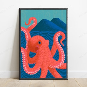 May include: A framed art print featuring a vibrant coral-pink octopus with textured skin and blue eyes, positioned in front of dark blue stylised ocean waves and two rounded mountain peaks against a light teal sky background.