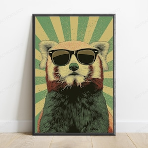 May include: A framed wall art print featuring a red panda wearing black sunglasses. The animal is centered against a background of radiating green and beige sunburst lines. The illustration uses a textured, vintage-inspired graphic style.