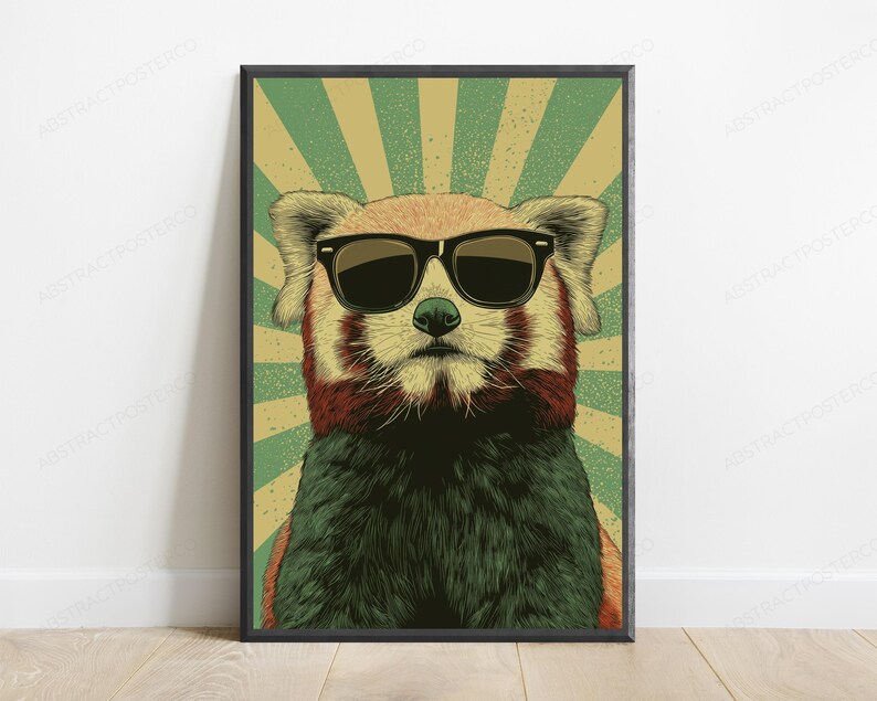 May include: A framed wall art print featuring a red panda wearing black sunglasses. The animal is centered against a background of radiating green and beige sunburst lines. The illustration uses a textured, vintage-inspired graphic style.