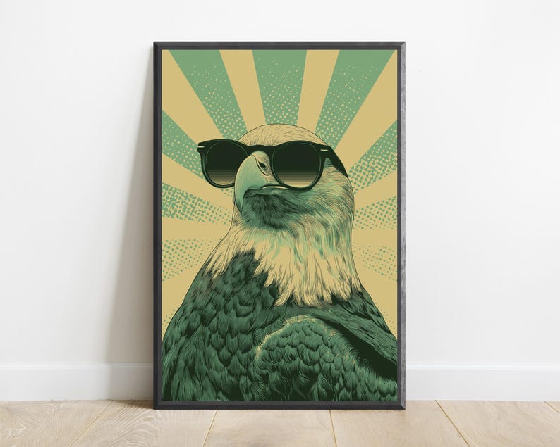 May include: A framed wall art print featuring a detailed illustration of a bald eagle wearing black sunglasses. The eagle is centered against a background of alternating light green and tan sunburst rays with a subtle dotted texture pattern.