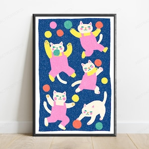 K&ouml;nnte beinhalten: Ein gerahmter Kunstdruck mit f&uuml;nf wei&szlig;en Katzen in rosa Latzhosen vor einem texturierten dunkelblauen Hintergrund. Die Katzen sind in verschiedenen verspielten Posen dargestellt, umgeben von verstreuten bunten Kreisen in Gelb, Orange, Pink und Gr&uuml;n.