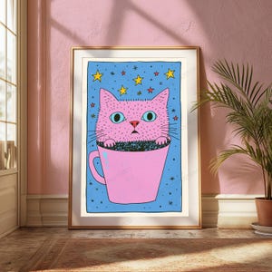 Pu&ograve; includere: Una stampa artistica incorniciata raffigurante un gatto rosa con grandi occhi azzurri seduto all'interno di una tazza rosa. Lo sfondo &egrave; di un blu vivace, arricchito da stelle gialle e piccoli accenti rossi. Stile illustrativo disegnato a mano.