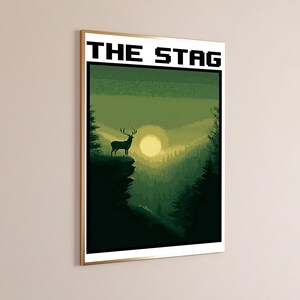 May include: A framed rectangular wall art print featuring a pixel art landscape with a stag standing on a cliff edge. The scene displays a forest in shades of green under a pale yellow sun. The text THE STAG is printed in black at the top.
