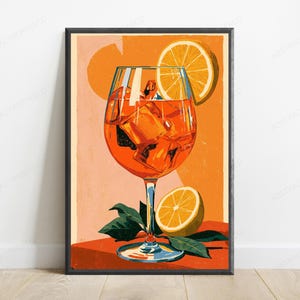 May include: A vertical art print featuring a vibrant orange cocktail in a stemmed glass filled with ice cubes. An orange slice garnish rests on the rim, and another half orange sits at the base with green leaves against a warm orange background.