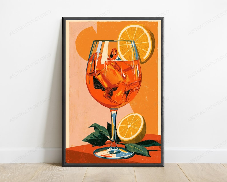 May include: A vertical art print featuring a vibrant orange cocktail in a stemmed glass filled with ice cubes. An orange slice garnish rests on the rim, and another half orange sits at the base with green leaves against a warm orange background.