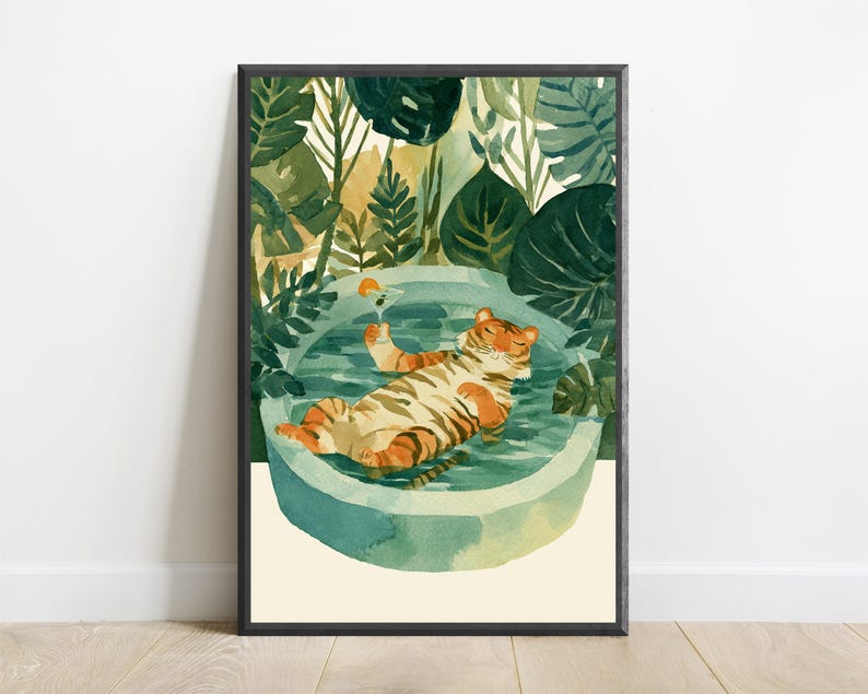 Peut inclure: Une impression d'art mural encadr&eacute;e repr&eacute;sentant un tigre aux rayures orange et noires flottant sur le dos dans une piscine ronde bleu clair. Le tigre tient un petit verre &agrave; cocktail avec une tranche d'orange. Entour&eacute; de feuillage vert fonc&eacute;.