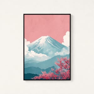 May include: A framed art print featuring a stylized depiction of Mount Fuji. The artwork showcases a snow-capped mountain against a pink sky, with blue-toned mountains in the background and pink cherry blossoms in the foreground. The print is in a black frame.
