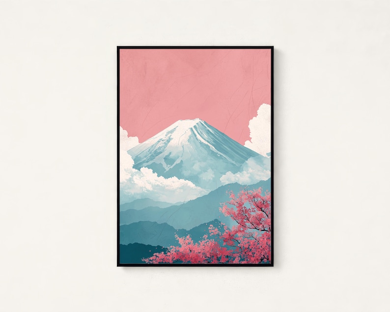May include: A framed art print featuring a stylized depiction of Mount Fuji. The artwork showcases a snow-capped mountain against a pink sky, with blue-toned mountains in the background and pink cherry blossoms in the foreground. The print is in a black frame.