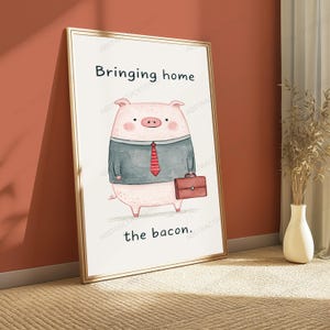 May include: A framed wall art print featuring a cartoon pig wearing a grey suit jacket and a red striped tie. The pig is holding a brown briefcase. The text "Bringing home" is printed above the pig, and "the bacon." is printed below it.