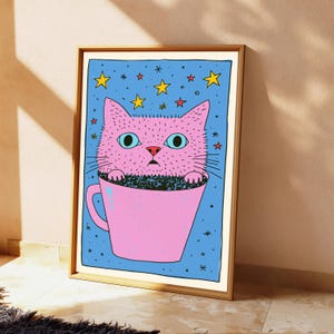 Pu&ograve; includere: Una stampa artistica incorniciata raffigurante un gatto rosa con grandi occhi color ottanio seduto all'interno di una tazza rosa. Lo sfondo &egrave; di un blu vibrante riempito con stelle gialle e rosse di varie dimensioni. L'illustrazione ha contorni neri.