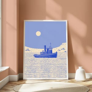 May include: A framed art print featuring a blue tugboat centered on a textured water surface under a pale moon. The background shows a light-colored shoreline with small structures. The illustration uses a monochromatic blue and cream color palette.