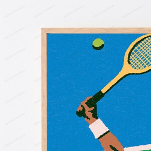 May include: A framed wall art print featuring a textured illustration of a tennis racket held by a hand wearing a white wristband, positioned against a solid blue background with a single green tennis ball floating in the upper portion of the frame.
