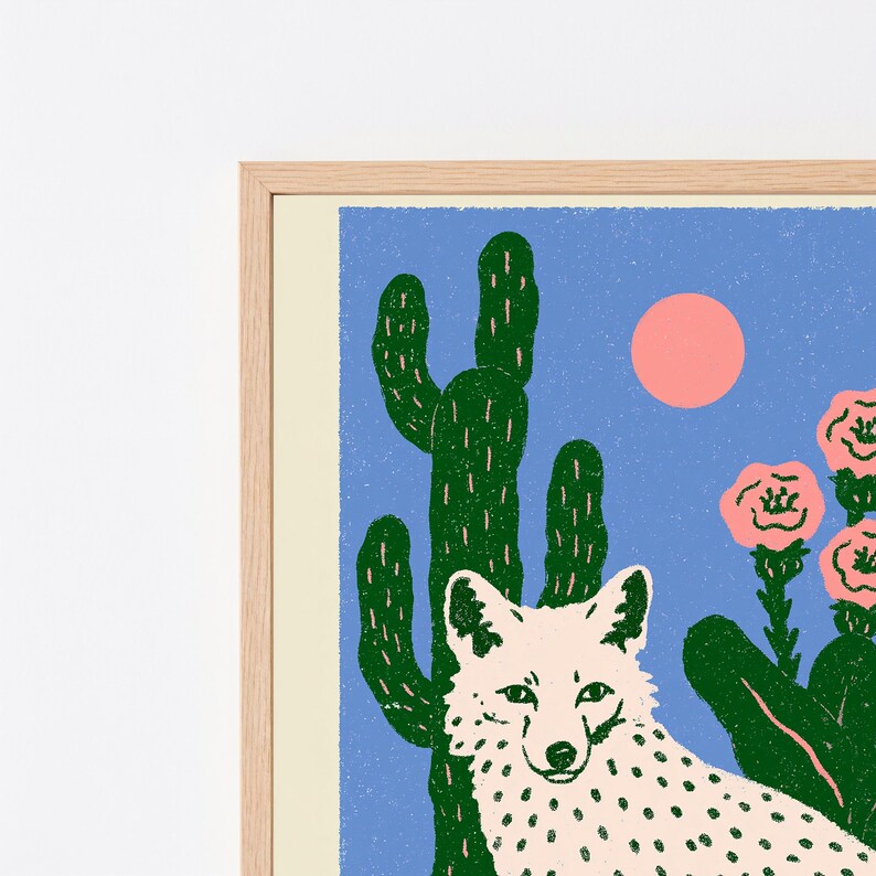 Pu&ograve; includere: Una stampa artistica incorniciata raffigurante una volpe color crema con macchie scure posizionata davanti a un alto cactus verde. Lo sfondo &egrave; blu solido con un sole circolare rosa e diversi fiori rosa su steli verdi a destra della volpe.