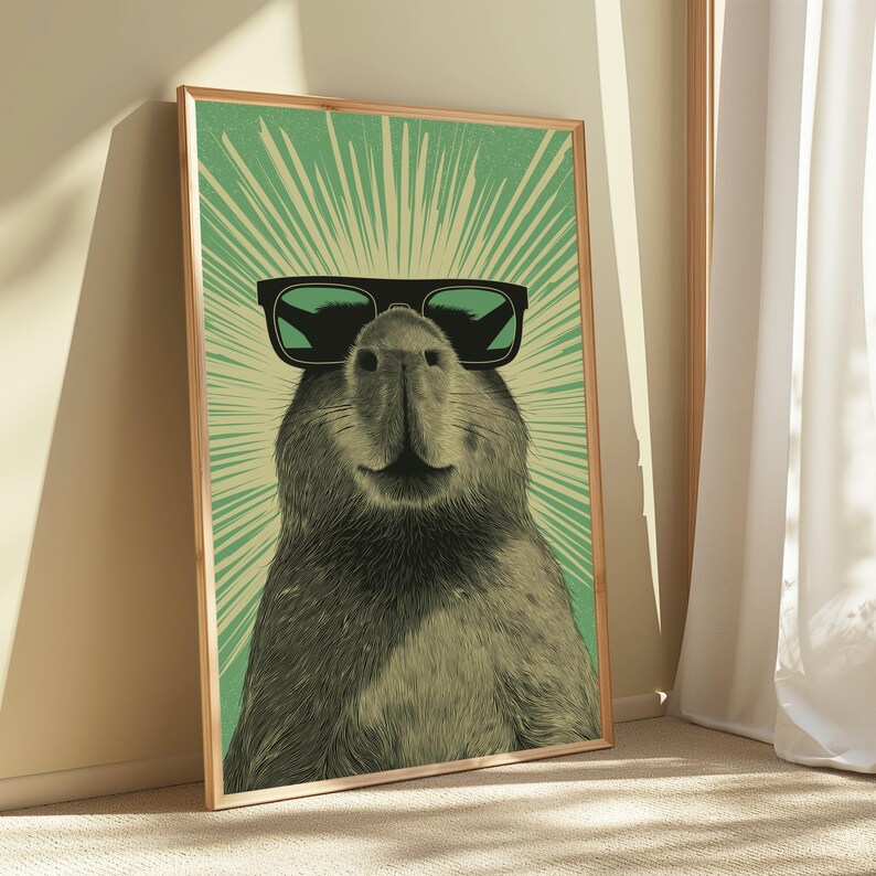 Peut inclure: Une impression d'art mural encadr&eacute;e repr&eacute;sentant une illustration monochrome d'un capybara portant des lunettes de soleil noires. Le capybara est centr&eacute; sur un fond vert clair avec des lignes de rayons de soleil blanches rayonnant vers l'ext&eacute;rieur.