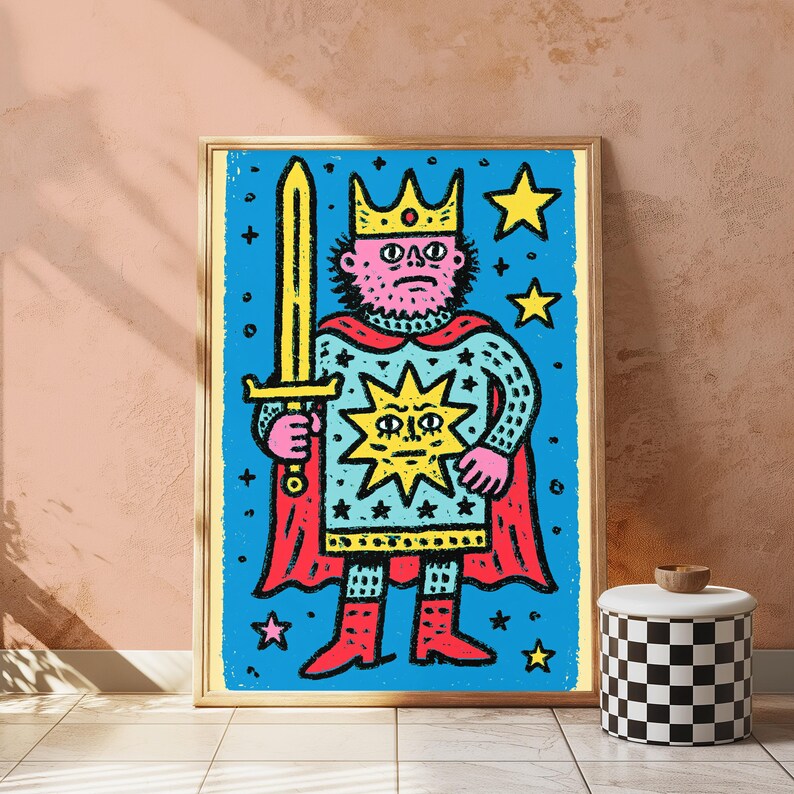May include: A framed art print featuring a stylized illustration of a king with a pink face, wearing a yellow crown and a red cape. The figure holds a yellow sword against a blue background filled with yellow stars and a central sun emblem.