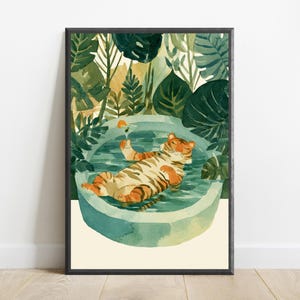 Peut inclure: Une impression d'art mural encadr&eacute;e repr&eacute;sentant un tigre aux rayures orange et noires flottant sur le dos dans une piscine ronde bleu clair. Le tigre tient un petit verre &agrave; cocktail avec une tranche d'orange. Entour&eacute; de feuillage vert fonc&eacute;.